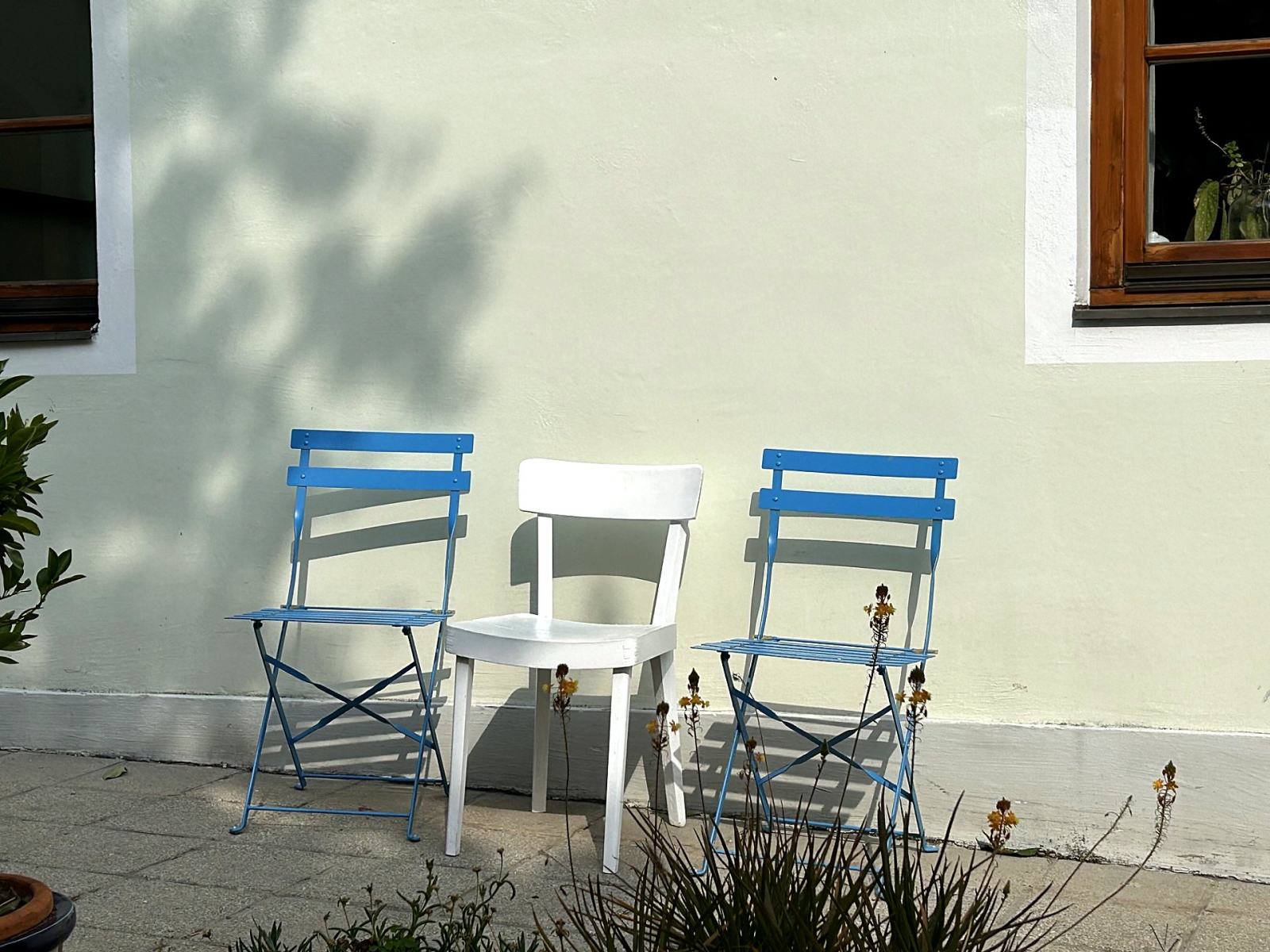 Stühle im Garten vor der Hauswand