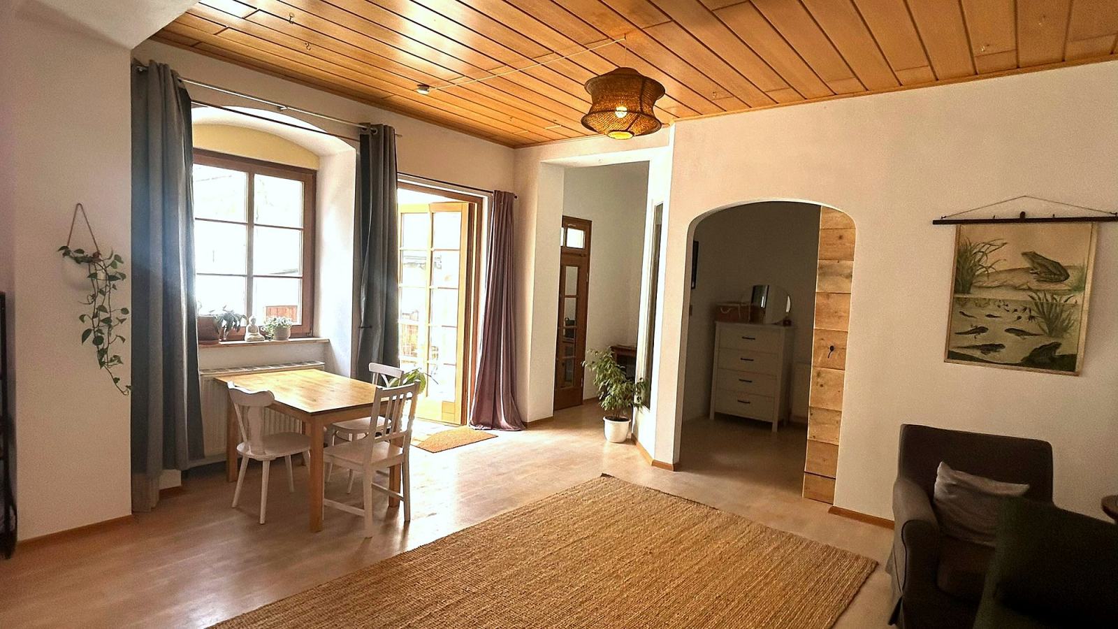 Wohnraum der Gartenwohnung mit Holzdecke und Essplatz