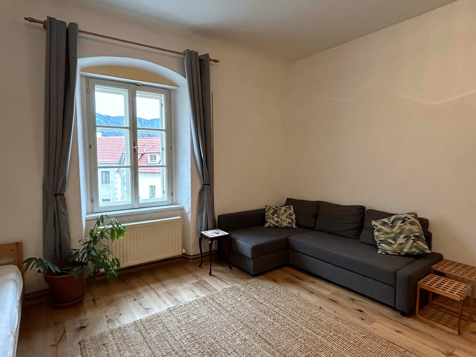 Wohnzimmer der Suite mit Sofa und Blick auf das Dorf